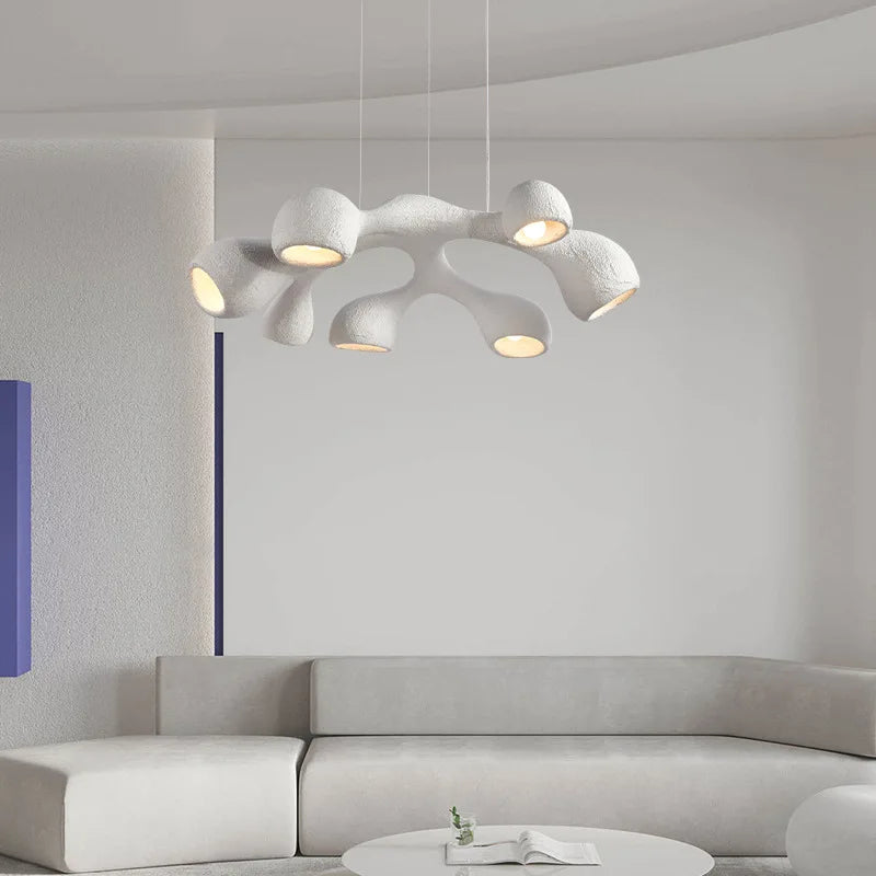 Odense Cocoon sculptural cloud pendant chandelier in white 7-head flat configuration hanging in an all-white minimalist living room with curved grey sectional sofa and round coffee table — LivDecor
