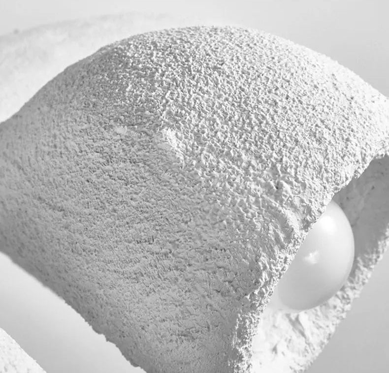 Odense Cocoon sculptural cloud pendant chandelier extreme close-up of single unlit cavity with globe bulb and rough textured white plaster-like exterior surface — LivDecor
