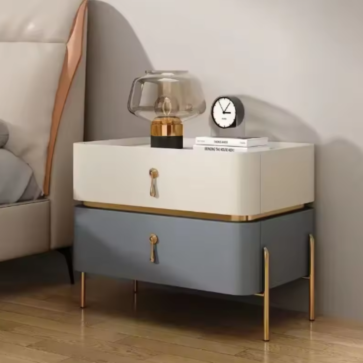 Slate top luxury two-tone beige and slate two-drawer nightstand with fluted drawer fronts, gold trim, drop-pull handles and slim tapered gold legs styled beside a bed with a glass lamp — LivDecor
