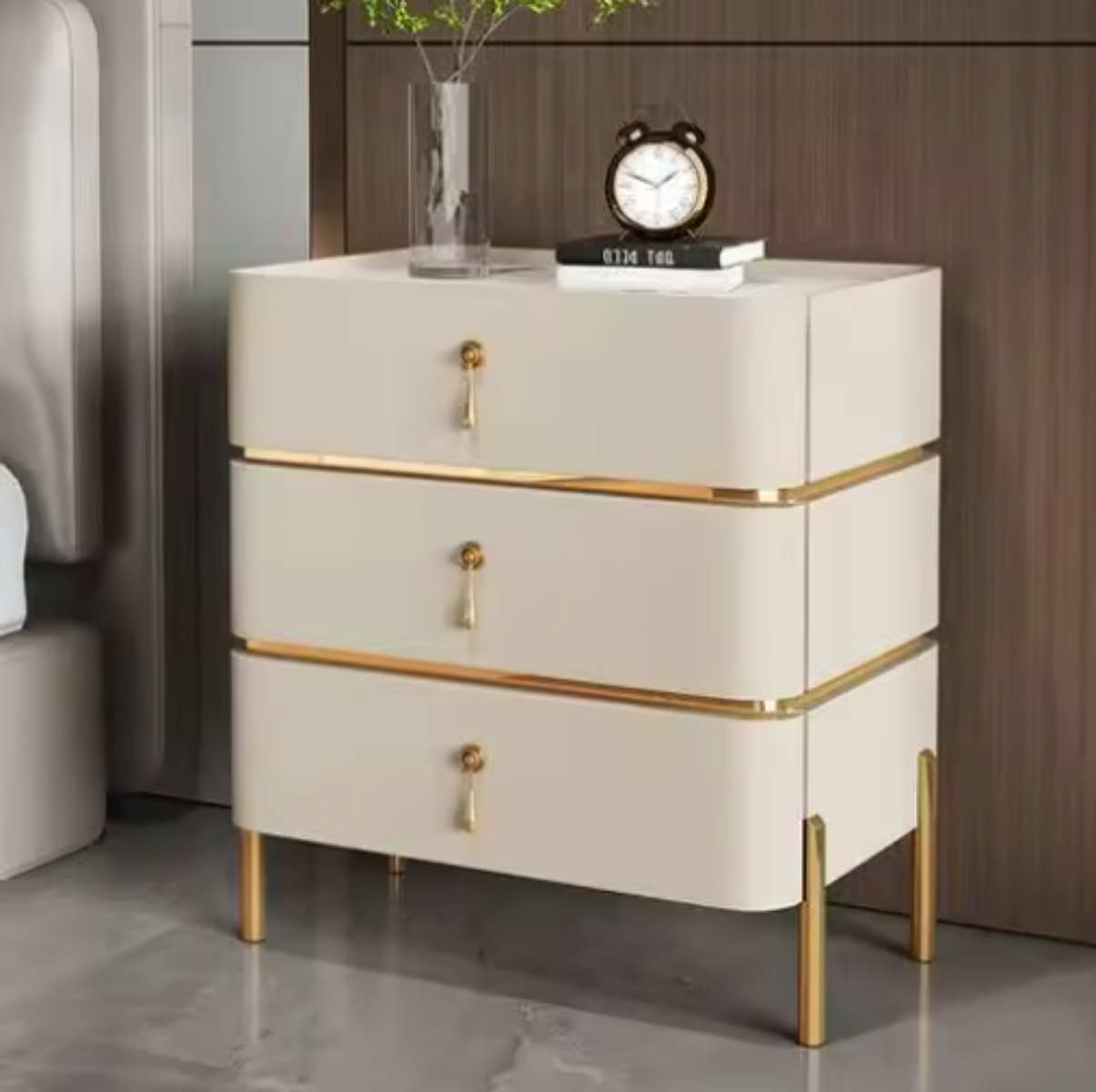 Slate top luxury beige three-drawer nightstand with white slate top, gold trim, drop-pull handles and slim tapered gold legs styled beside a bed against a walnut wall — LivDecor
