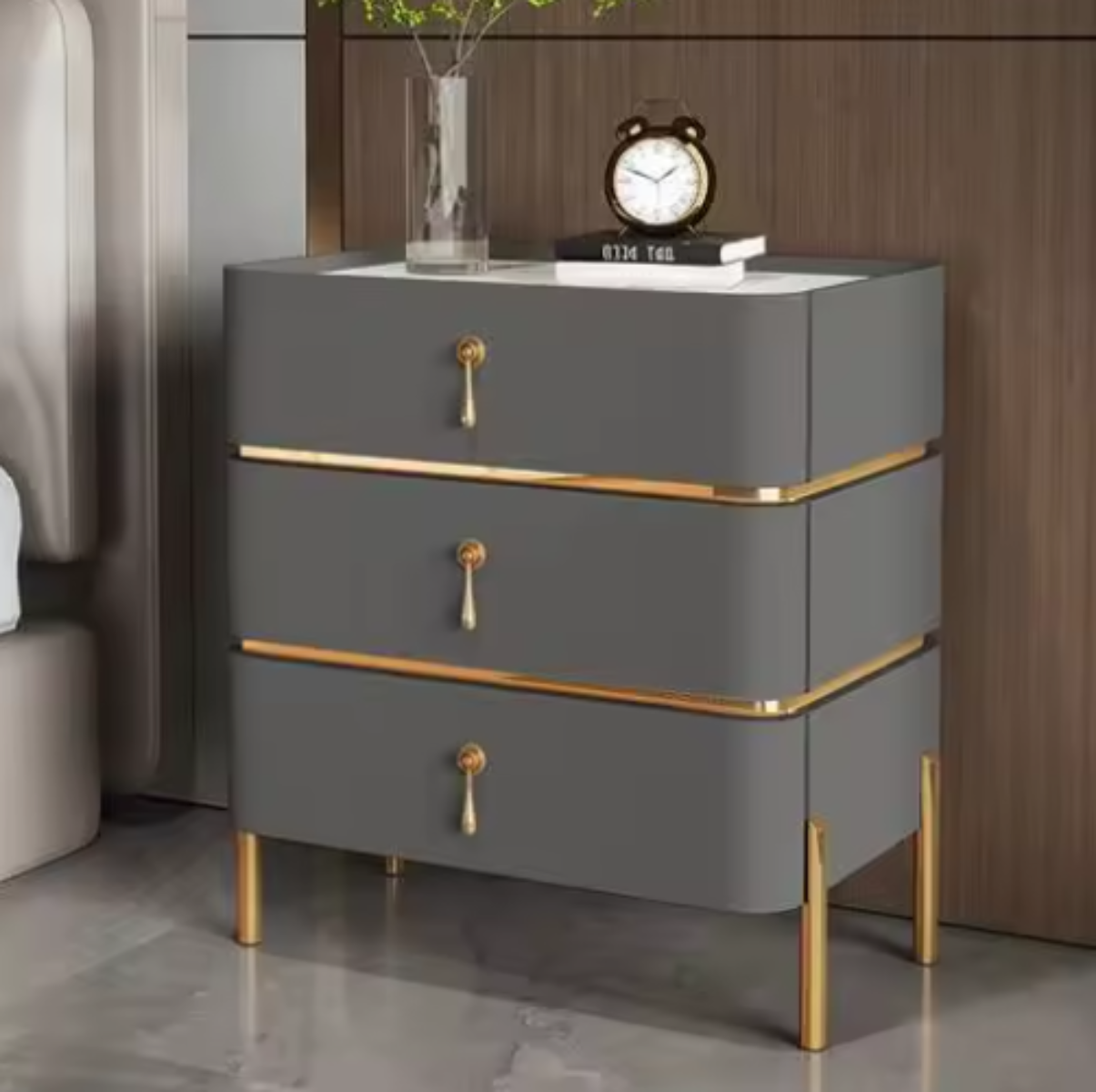 Slate top luxury charcoal three-drawer nightstand with white slate top, gold trim, drop-pull handles and slim tapered gold legs styled beside a bed against a walnut wall — LivDecor
