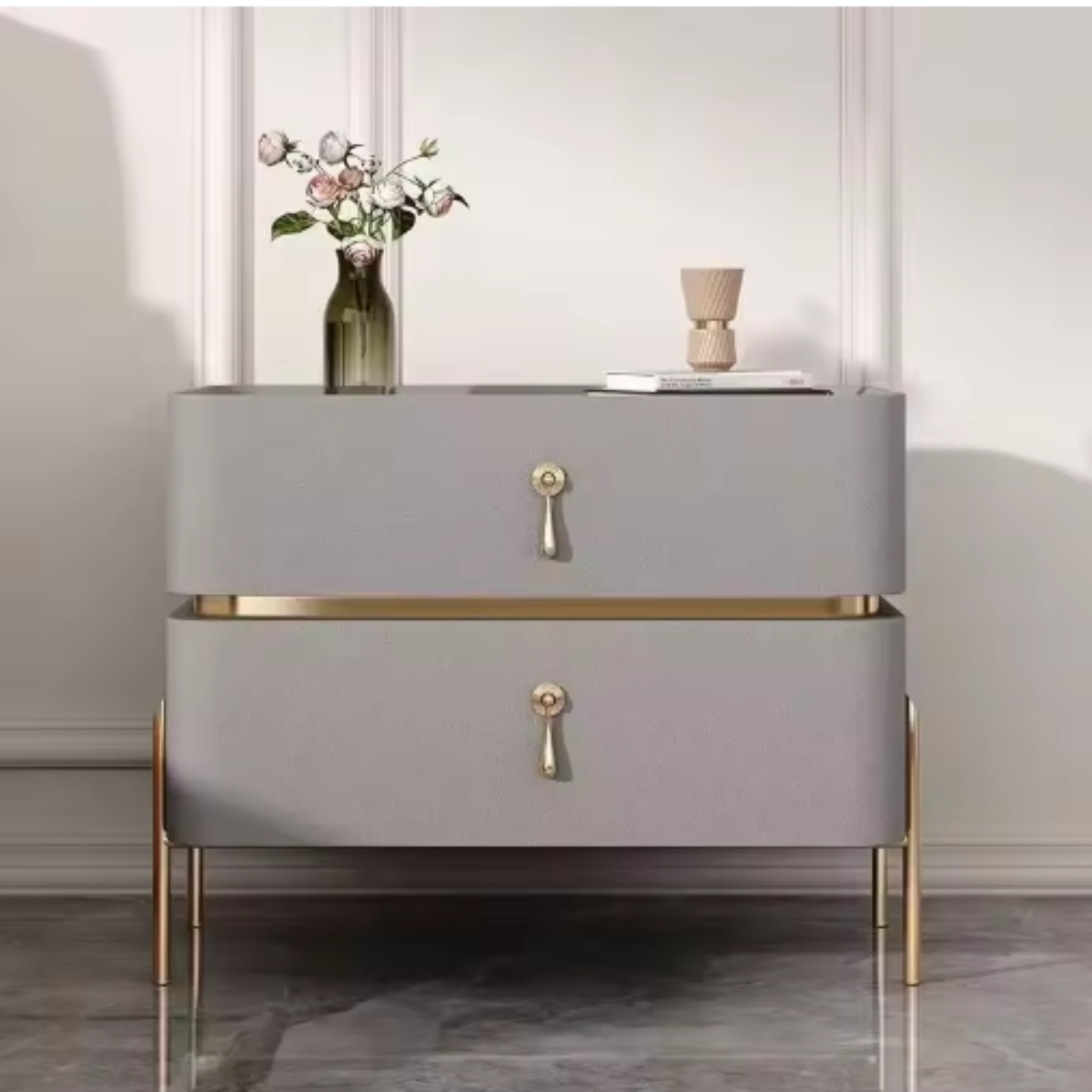 Slate top luxury dove grey two-drawer nightstand with gold trim, drop-pull handles and slim tapered gold legs shown front-on with a vase of roses against a paneled wall — LivDecor

