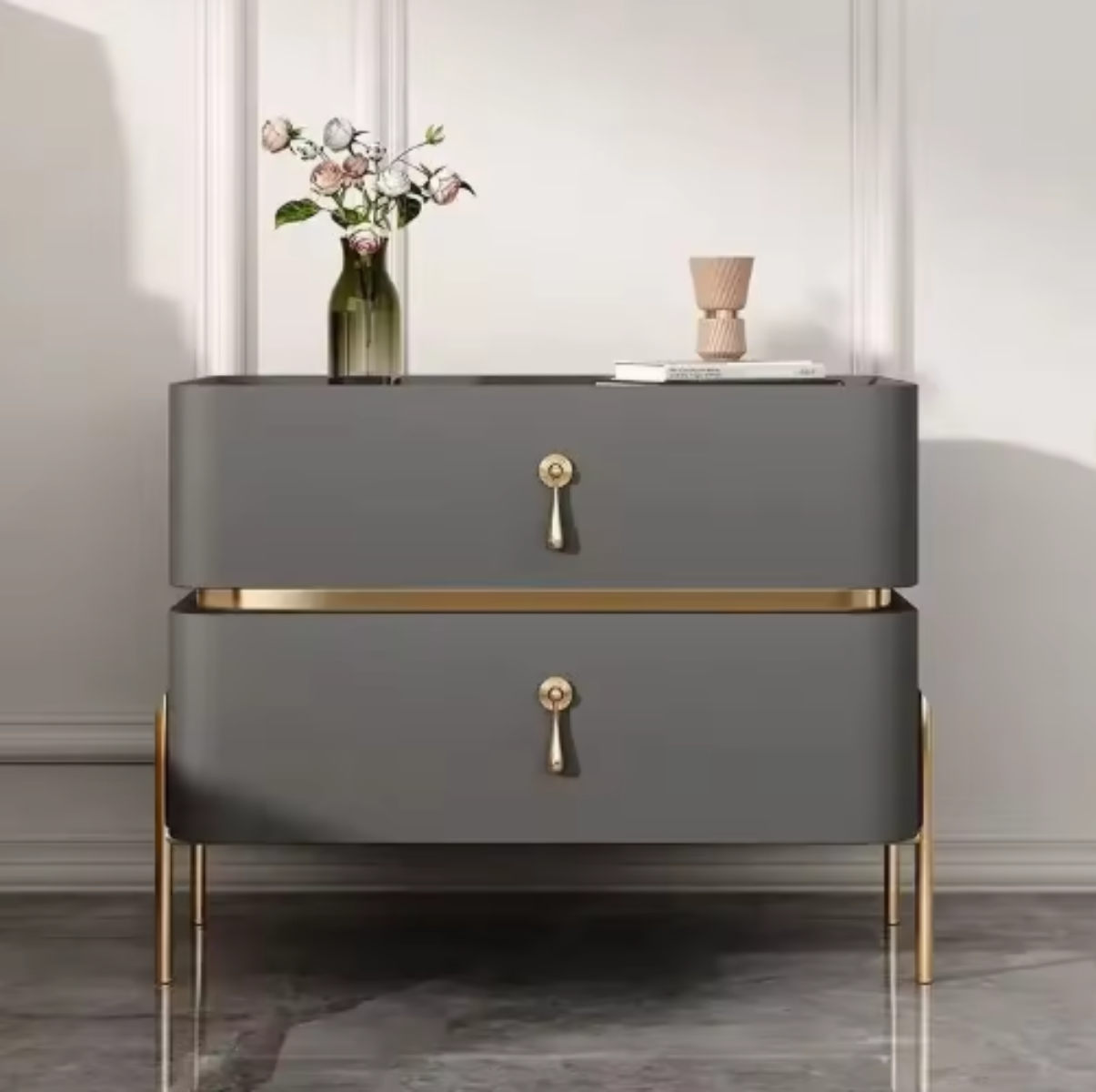 Slate top luxury grey two-drawer nightstand with gold trim, drop-pull handles and slim tapered gold legs, styled with a vase of roses against a paneled wall — LivDecor
