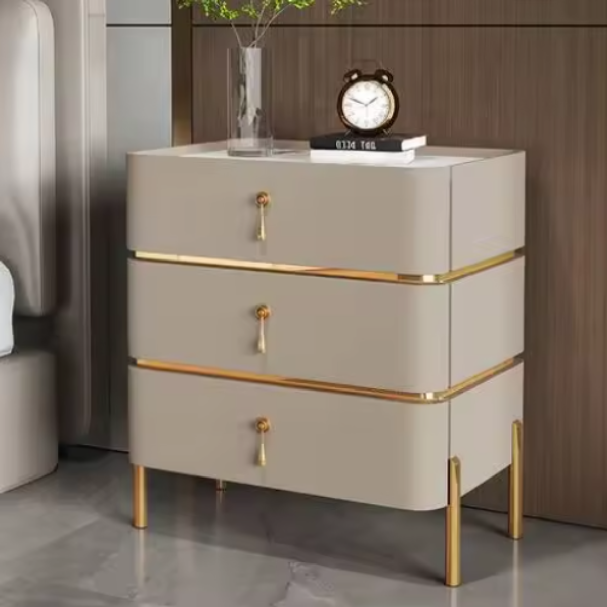 Slate top luxury khaki three-drawer nightstand with white slate top, gold trim, drop-pull handles and slim tapered gold legs styled beside a bed against a walnut wall — LivDecor
