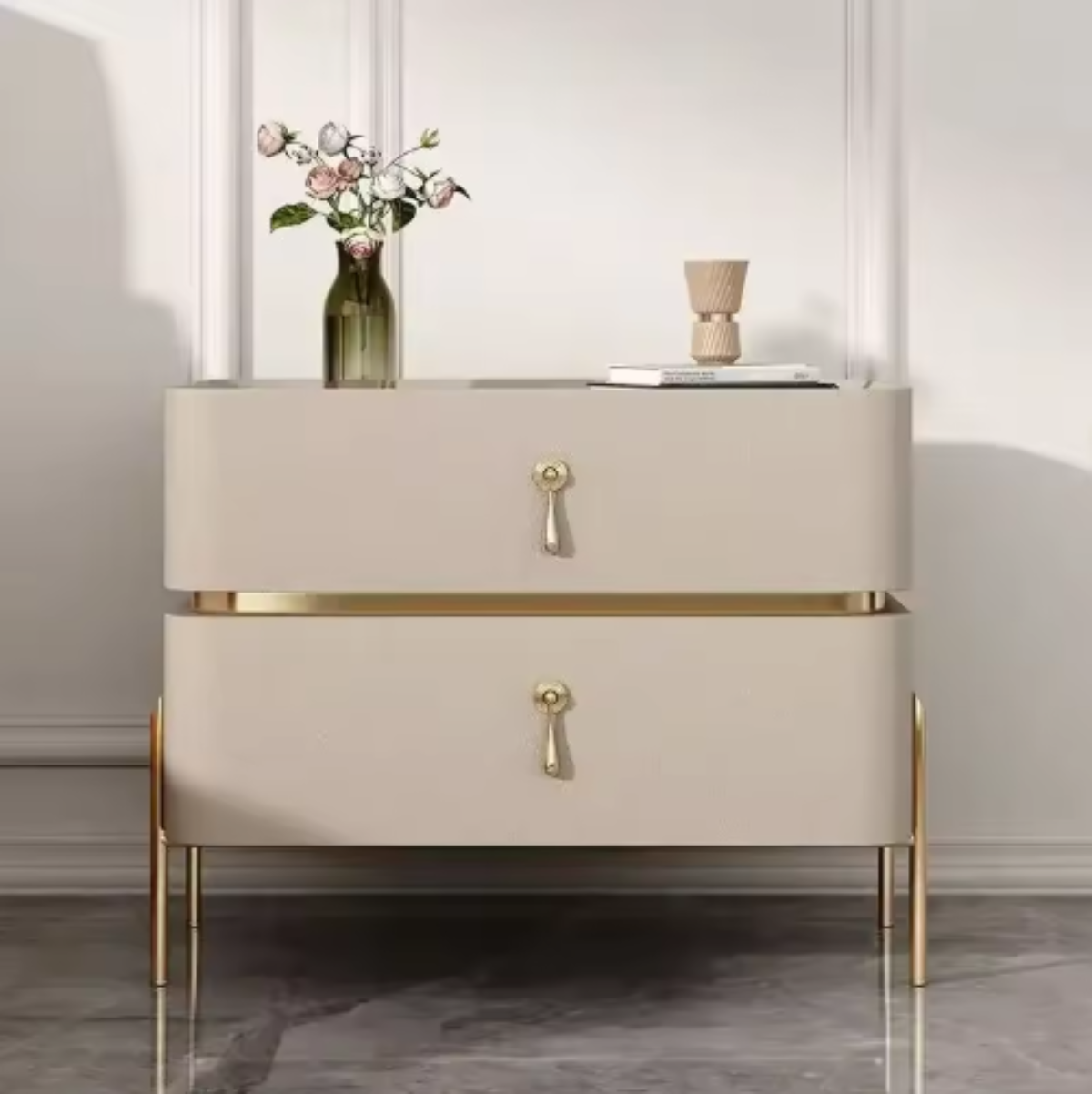 Slate top luxury khaki two-drawer nightstand with gold trim, drop-pull handles and slim tapered gold legs shown front-on with a vase of roses against a paneled wall — LivDecor
