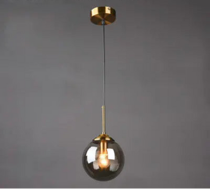 Single smoke grey glass globe pendant light on gold cord and ceiling mount displayed against a neutral grey background — LivDecor