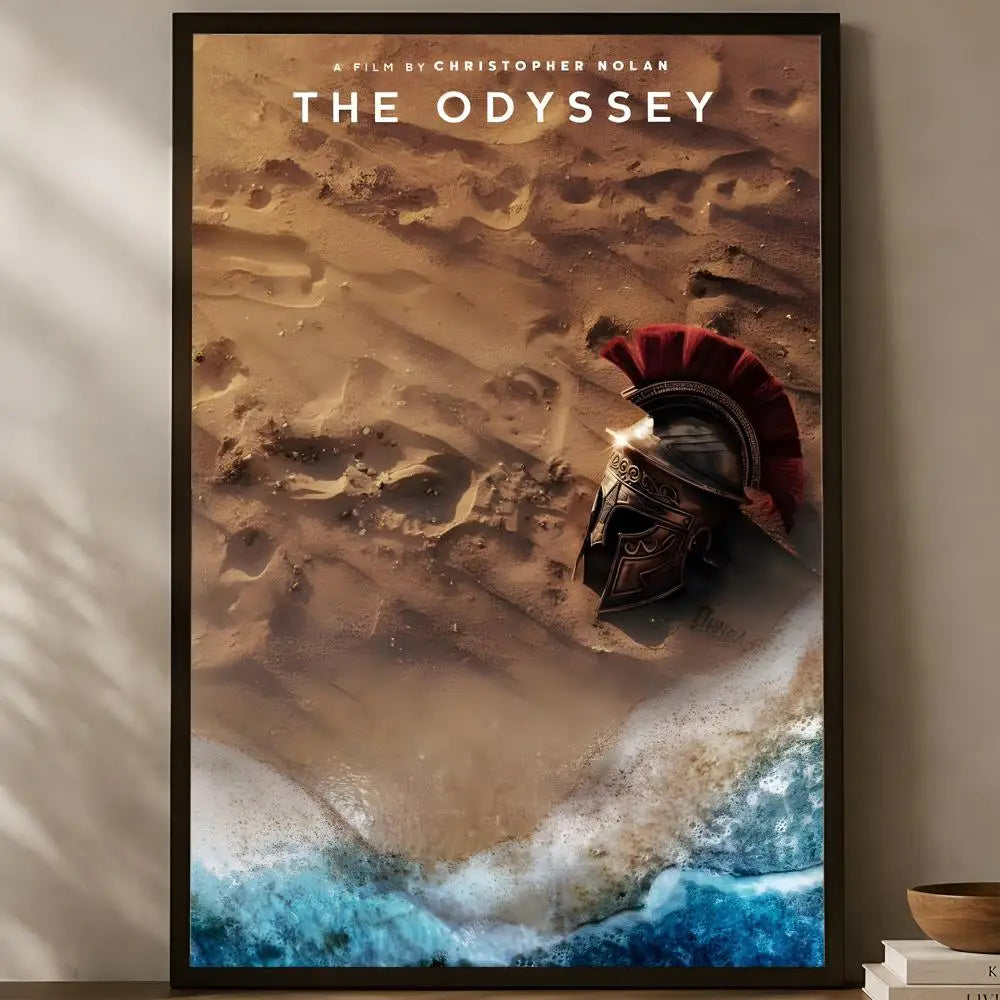 The Odyssey Christopher Nolan official aerial view red-plumed Greek helmet half-buried at desert sand meets teal ocean shore poster displayed on a warm natural light shelf — LivDecor
